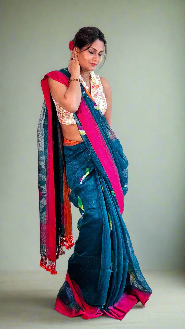 Woman wearing a blue saree with pink border indoors